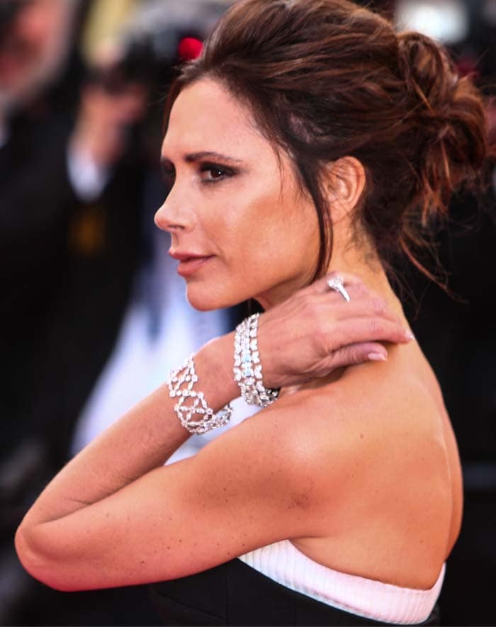 Victoria Beckham stuns in a strapless black and white dress, elegantly accessorized with sparkling Chopard jewelry at the 69th Cannes Film Festival