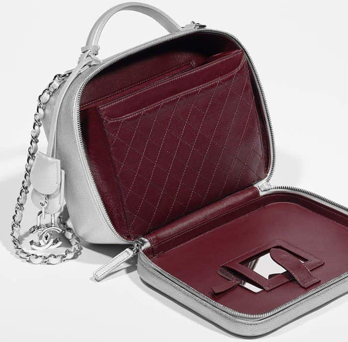 This silver Chanel Vanity Case opens to reveal a luxurious burgundy quilted interior with a built-in mirror, combining elegance with functional design