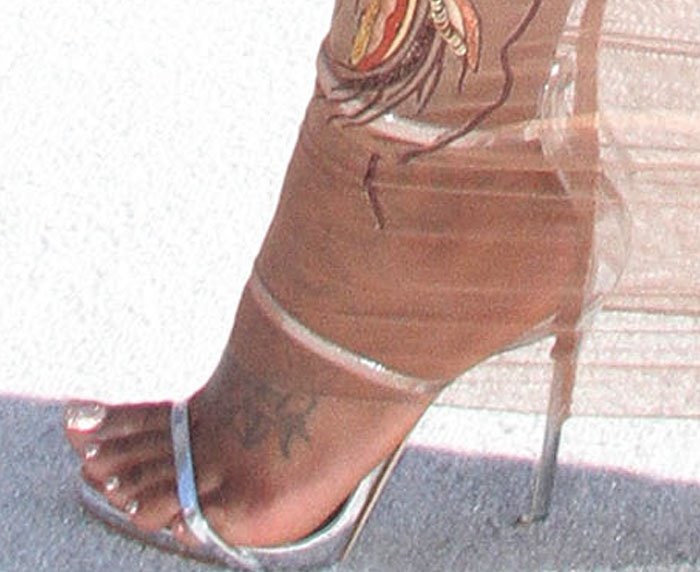 A closer look at Fantasia Barrino’s feet reveals her metallic silver Giuseppe Zanotti “Coline” sandals, featuring delicate straps and a towering stiletto heel that elongates her 5'6" frame