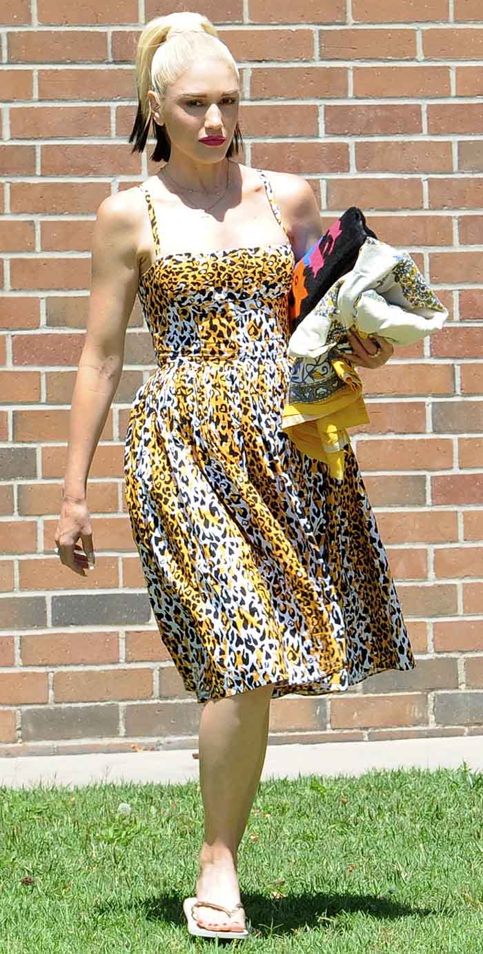 Gwen Stefani is carrying a colorful Chanel fur clutch along with what appears to be a folded blanket or towel