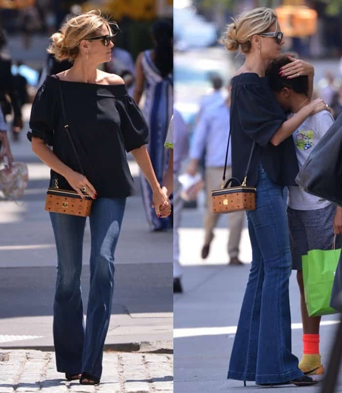 Heidi Klum styled her MCM Rockstar vanity case crossbody-style, letting the structured bag rest at her hip to complement her off-shoulder top and flared jeans for a sleek, hands-free look perfect for a chic day out with her kids