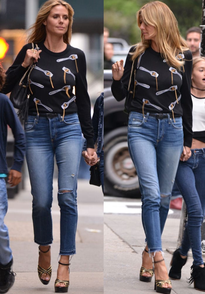 Heidi Klum pairs her quirky spaghetti-print sweater by Libertine with distressed cutoff jeans and gold-and-black platform sandals for a chic, off-duty street-style look