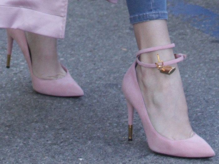 Khloé Kardashian’s pink suede Tom Ford padlock pumps feature slim ankle straps, gold lock charms, and metallic heel tips for a signature statement finish