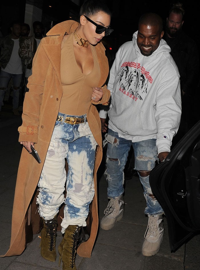 Kim Kardashian and Kanye West coordinate distressed denim and muted earth tones as they head out in London, with her towering olive Yeezy boots extending the tonal palette to the ground