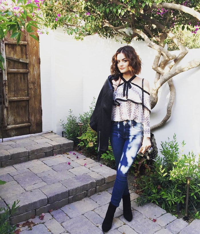 Lucy Hale carries a leather Kate Spade jacket to match her premiere look
