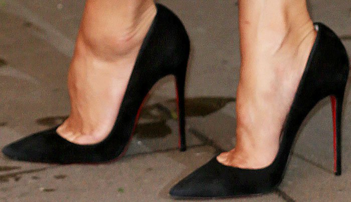 Nicole Scherzinger’s feet in classic black Christian Louboutin “So Kate” pumps, featuring the designer’s signature red-lacquered soles, a sharply pointed toe, and a 120 mm stiletto heel that adds height and sleek sophistication to her white Nicholas Oakwell dress