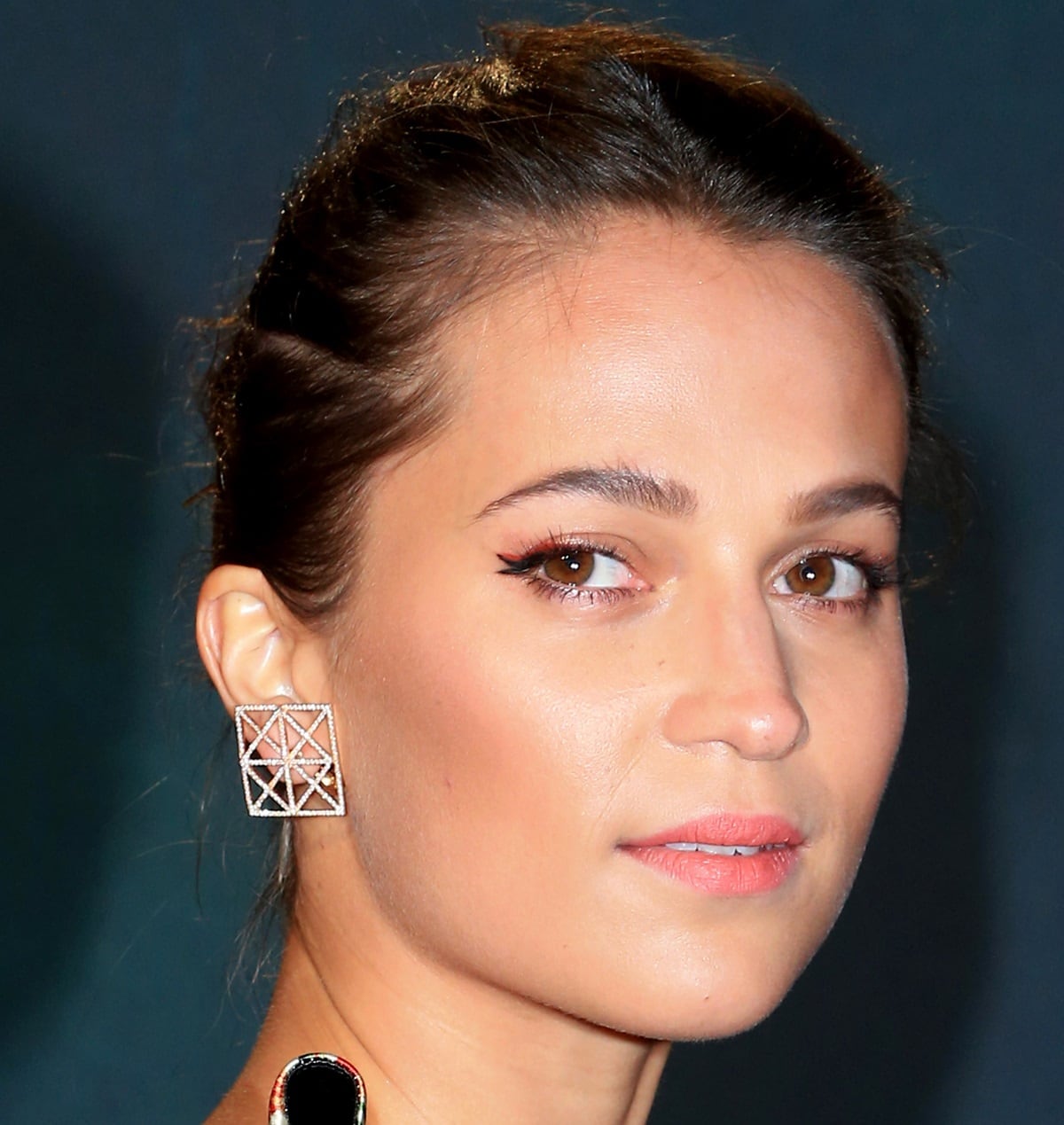 Alicia Vikander highlights her natural beauty with glowing skin, soft brown hair, and a subtle winged liner — features that have sometimes sparked misconceptions about her Swedish heritage despite being born and raised in Gothenburg