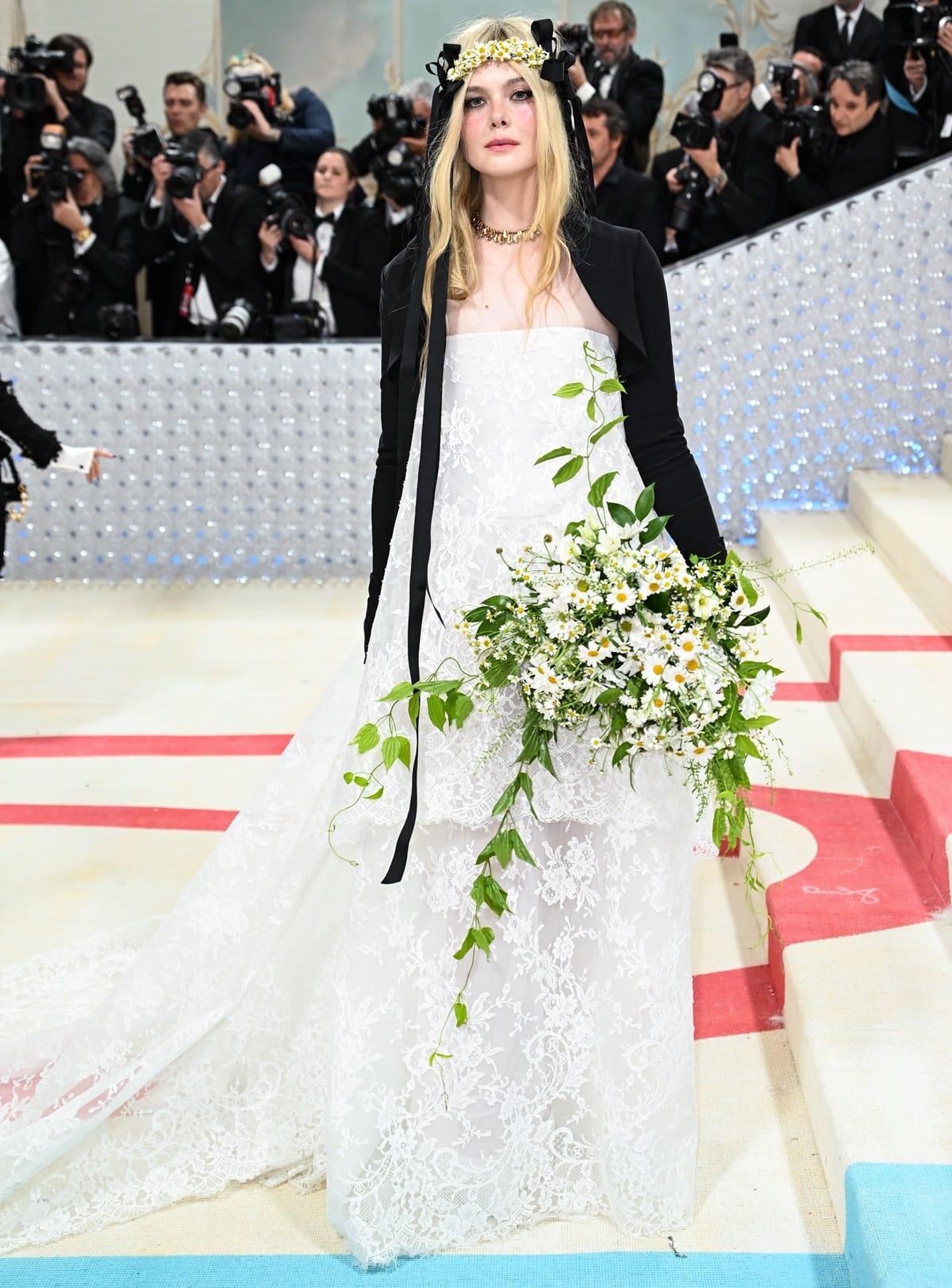 Elle Fanning's hair was styled in loose waves, falling effortlessly down her back, while Cartier jewelry added a touch of elegance to the ensemble
