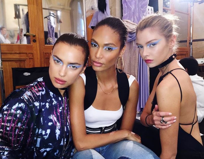 Joan Smalls poses backstage at Paris Haute Couture Fashion Week with fellow models Irina Shayk and Stella Maxwell, all sporting Versace’s bold icy-blue eye makeup look
