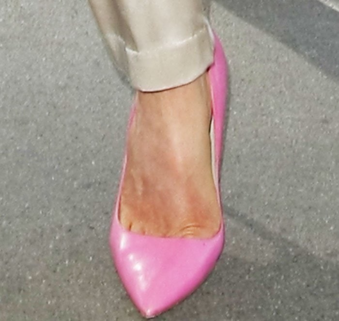A close-up of Kate Beckinsale’s bubblegum-pink Salvatore Ferragamo “Susie” patent pumps, adding a playful pop to her neutral outfit
