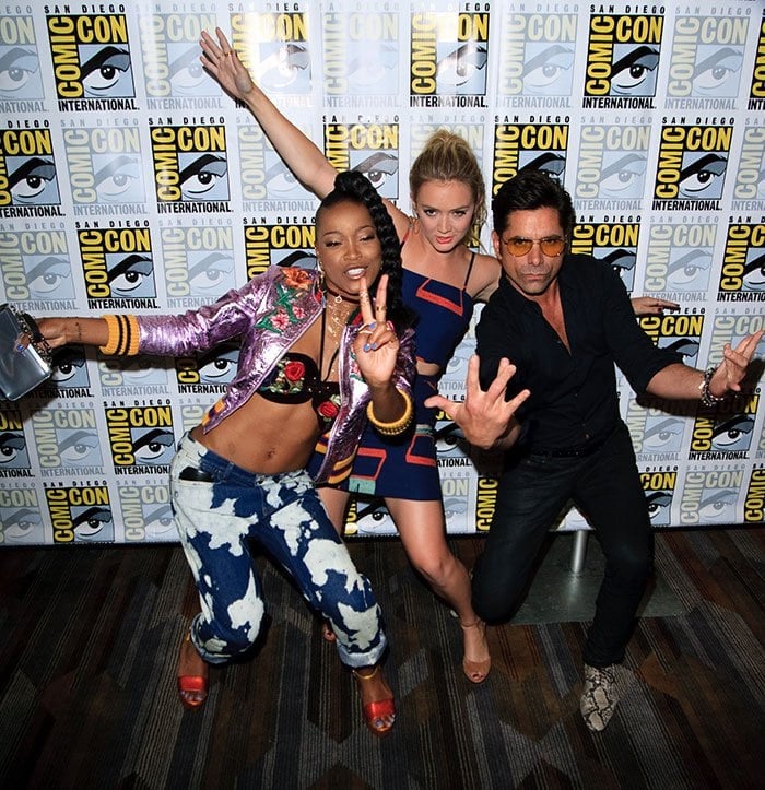 Keke Palmer joins Billie Lourd and John Stamos in a playful pose at San Diego Comic-Con, showcasing their lively Scream Queens camaraderie on the press line
