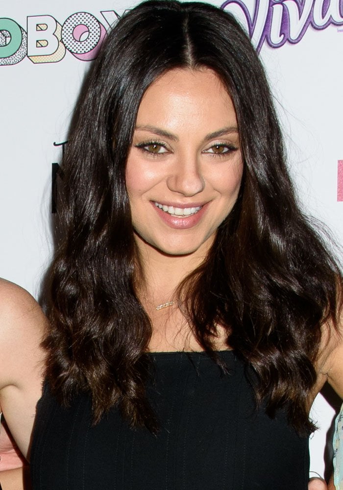 Mila Kunis wore her dark hair in loose waves and kept her makeup soft and natural, complementing the effortless feel of her relaxed maternity look