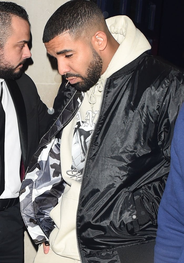 Drake leaves the nightclub separately from Rihanna, keeping a low profile in a black bomber jacket and a hoodie