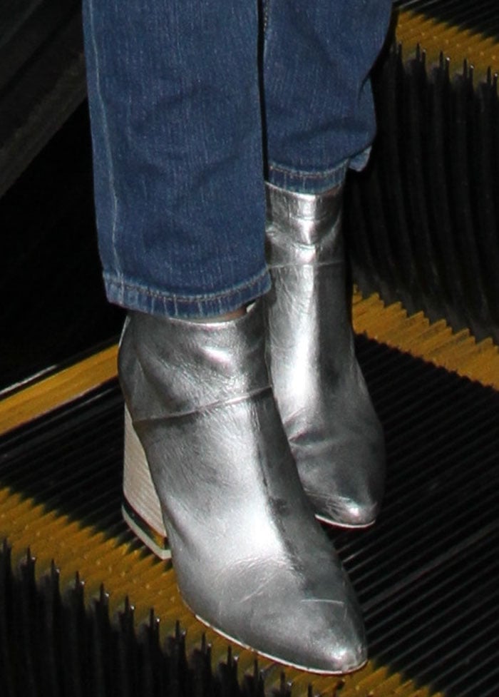 A close-up reveals the pointed toes and stacked heels of Victoria Justice’s metallic Ash “Indy” ankle boots