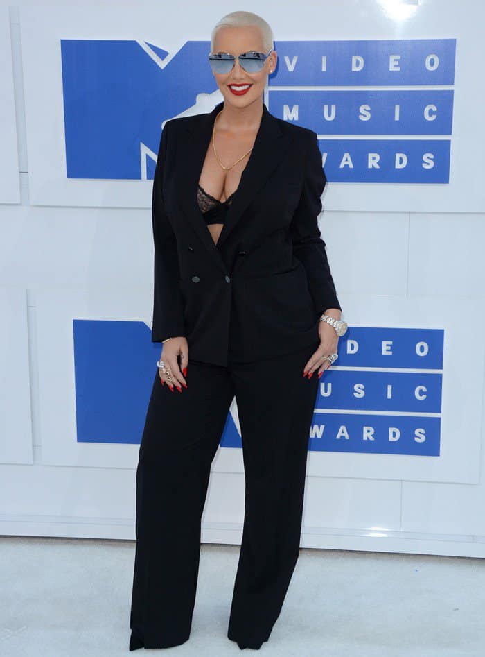 Amber Rose commands the red carpet in a tailored Tom Ford pantsuit layered over a lace La Perla bra, with sharply pointed Dior pumps peeking out beneath her wide-leg trousers