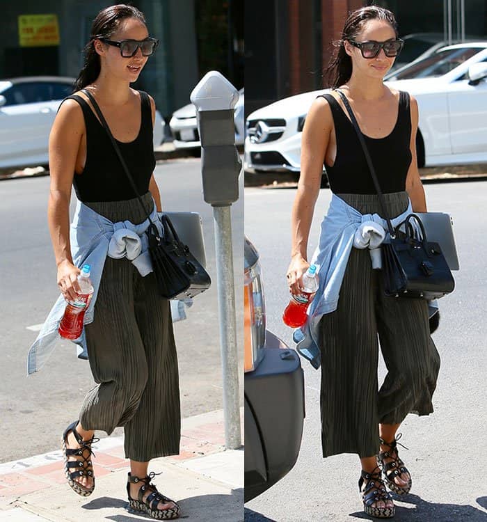 Cara Santana completes her effortlessly cool outfit with oversized sunglasses, a structured black handbag, and a tied denim shirt for a stylish, functional touch