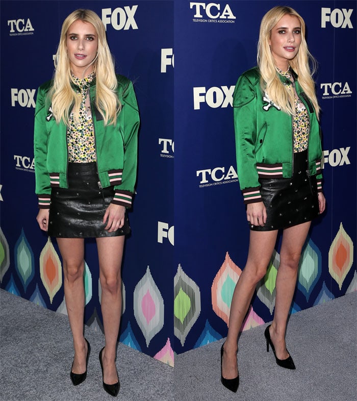 Emma Roberts pairs a studded leather mini skirt with a vibrant green satin bomber, grounding the look with sleek black pointed-toe pumps that elongate her legs and sharpen the edgy silhouette