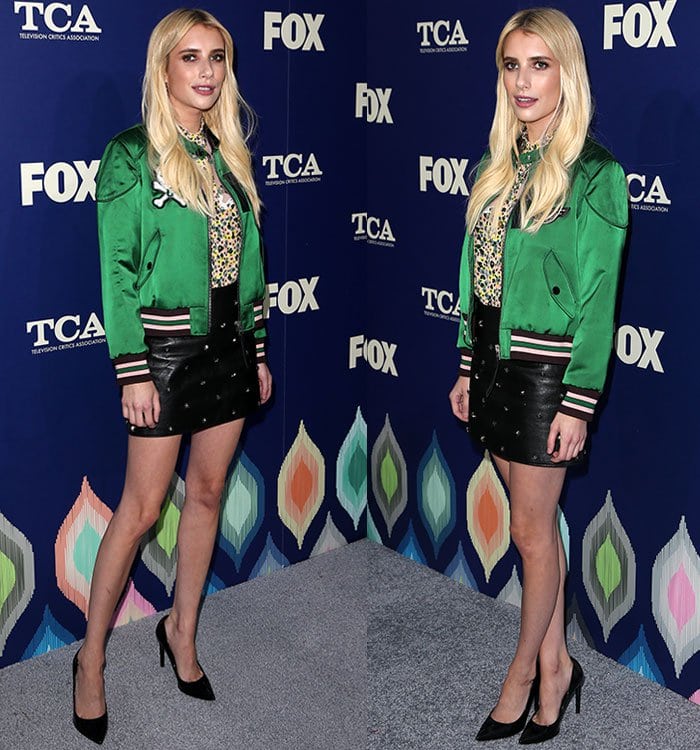 Emma Roberts pairs a vivid green satin bomber and studded leather mini skirt with sleek black pointed-toe Saint Laurent pumps, the sharp 110mm stilettos adding a polished, leg-lengthening finish to the edgy look