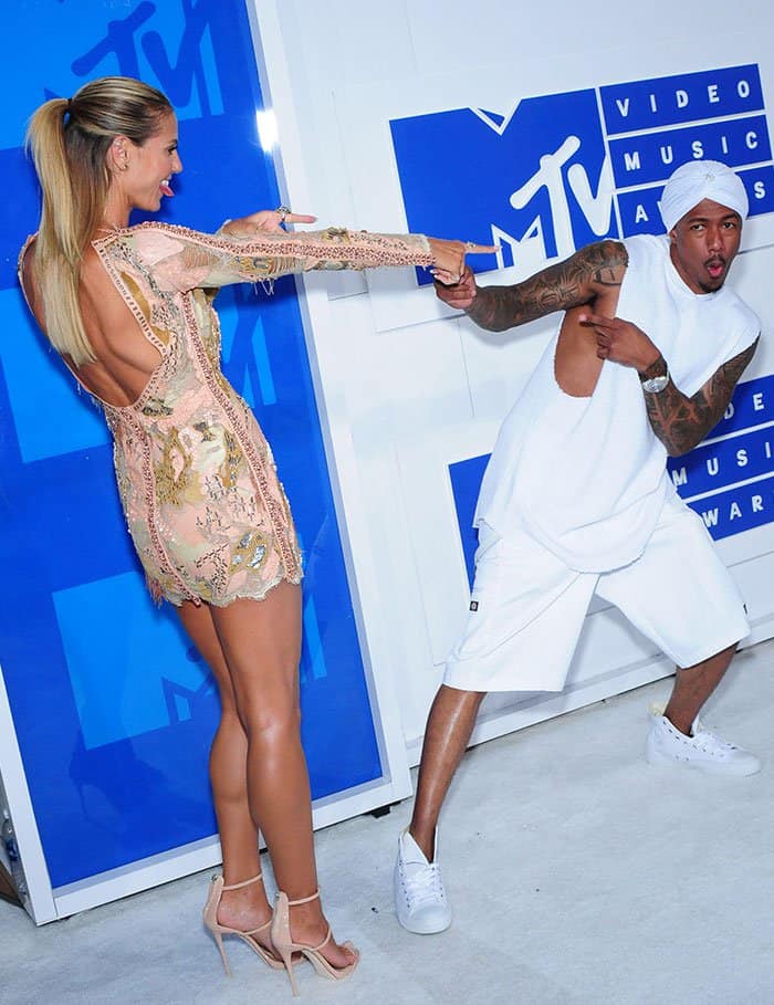 Nick Cannon rocking a loose top, a turban, baggy shorts, and trainers