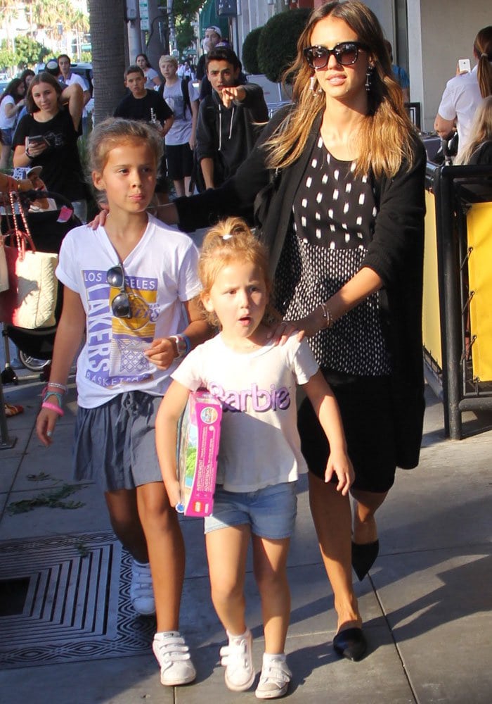 Jessica Alba keeps it effortlessly chic in Narciso Rodriguez snake-trim mules, pairing the sleek flats with Adornmonde Ra silver geometric hoop earrings, a Cartier Juste Un Clou bracelet, and The Honest Company Honest City Backpack while shopping with her daughters in Beverly Hills