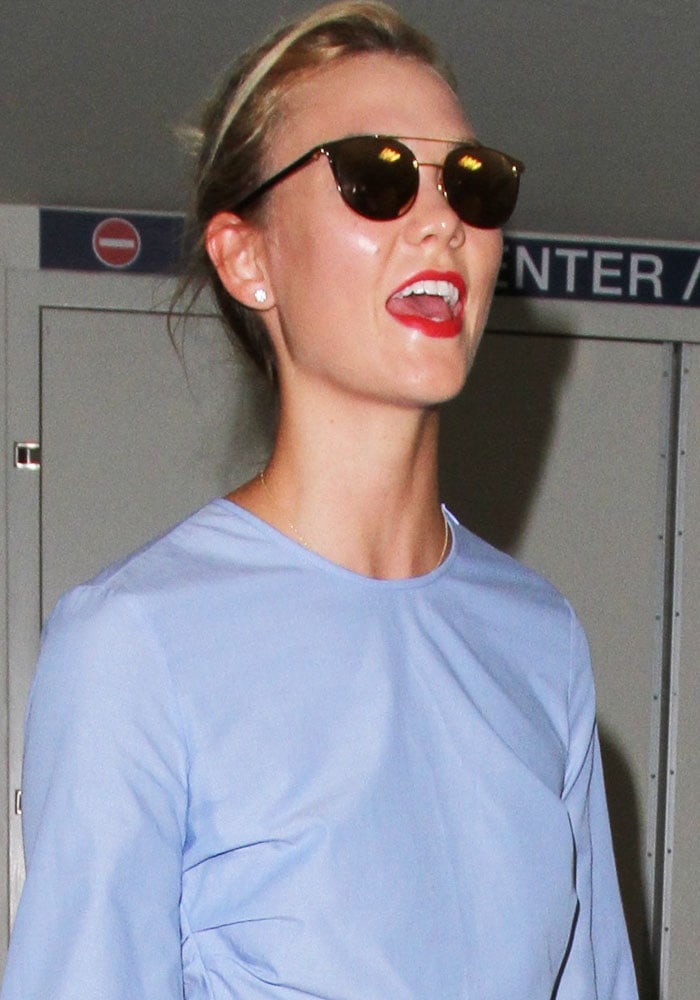 Karlie Kloss arrives at Los Angeles International Airport on August 16, 2016, polishing her off-duty travel look with minimalist Linda Farrow sunglasses and a fresh red lip for effortless airport chic