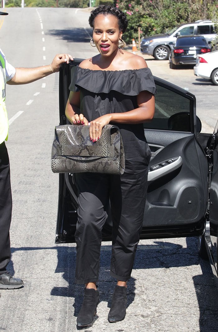 Kerry Washington arrives in a black off-the-shoulder Hatch jumpsuit, adding a statement snakeskin clutch for an effortlessly chic maternity look