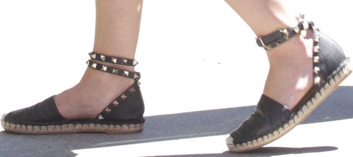 Lucy Hale sharpens her off-duty look with black Valentino “Rockstud” espadrille flats, the jute sole and signature pyramid-studded ankle straps adding a subtle edge to the relaxed silhouette