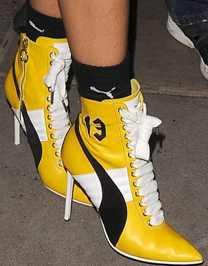Rihanna wears black crew socks with yellow Fenty x Puma Fall 2016 collection boots