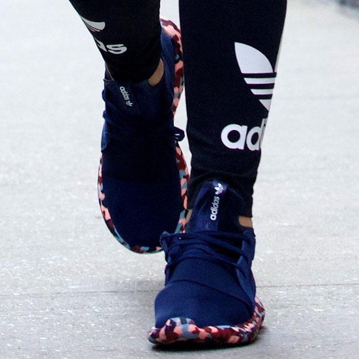 Close-up of Rita Ora's navy Adidas Tubular Defiant sneakers with pink burgundy and blue sole accents