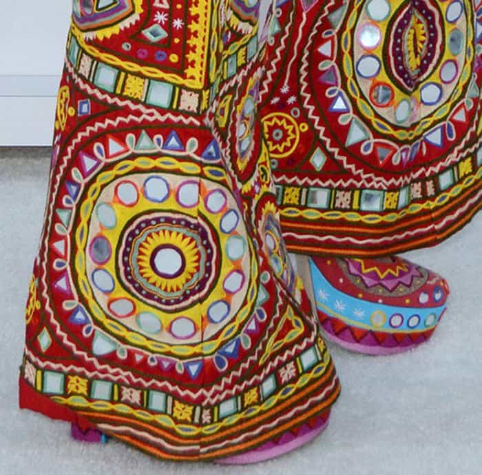 The mirrored circular motifs continue down to the footwear, where the elevated platform construction adds both visual weight and runway-level impact