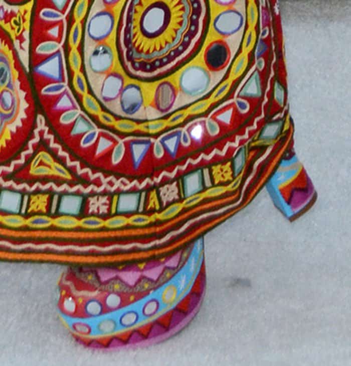 A closer look at the shoes highlights the exaggerated platform sole and block heel, wrapped in the same kaleidoscopic pattern for a seamless head-to-toe statement