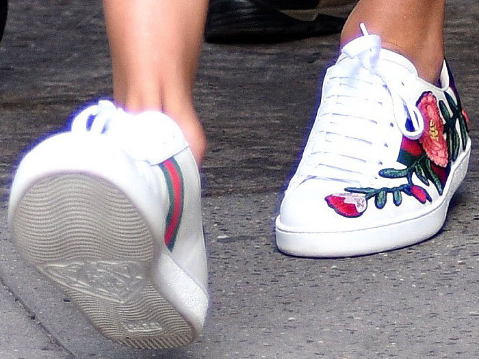 Taylor Swift steps out in Gucci’s floral-embroidered “New Ace” sneakers, showcasing the brand’s iconic Web stripe and signature mismatched metallic heel tabs