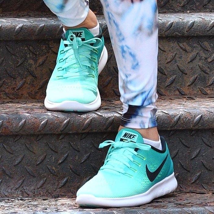 Teal Nike “Free RN” sneakers anchor Taylor Swift’s gym look, featuring a lightweight mesh upper and flexible, barefoot-inspired sole designed for natural movement and all-day comfort