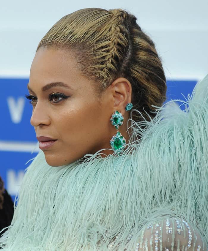 Beyoncé's sleek braided hairstyle is perfectly complemented by her statement Lorraine Schwartz emerald and diamond earrings
