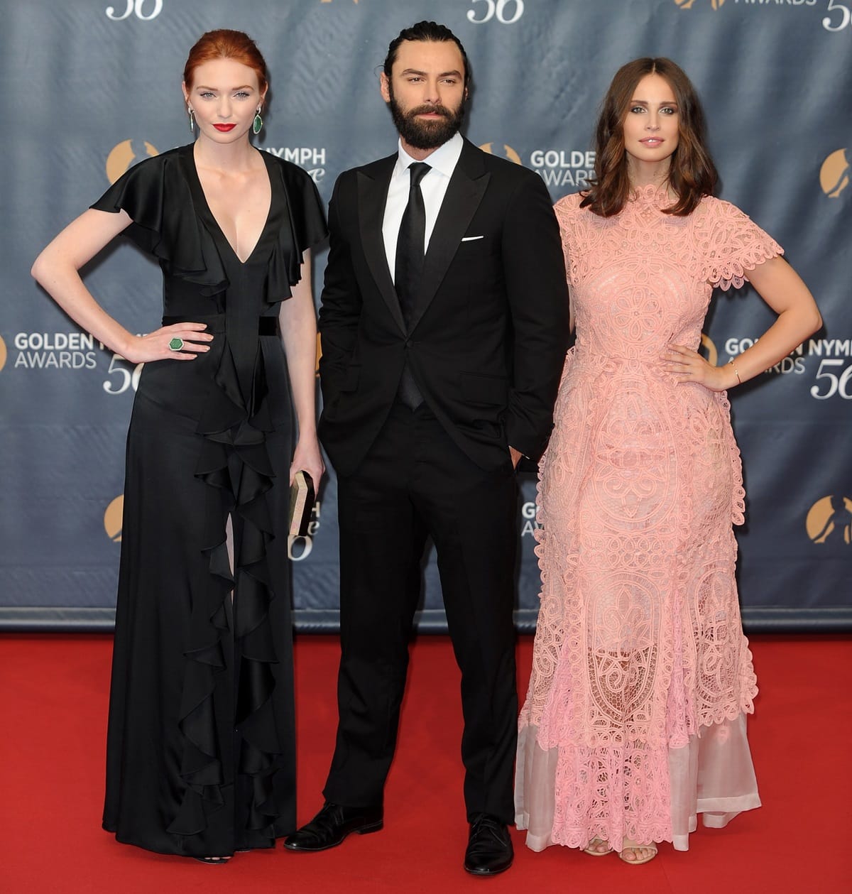 Eleanor Tomlinson, Aidan Turner, and Heida Reed dazzle on the red carpet, with Eleanor elongating her frame in a plunging black ruffled gown and heels, while Heida stuns in a delicate pink lace dress paired with nude platform sandals at the 56th Monte Carlo TV Festival Closing Ceremony and Golden Nymph Awards at The Grimaldi Forum on June 16, 2016, in Monte-Carlo, Monaco