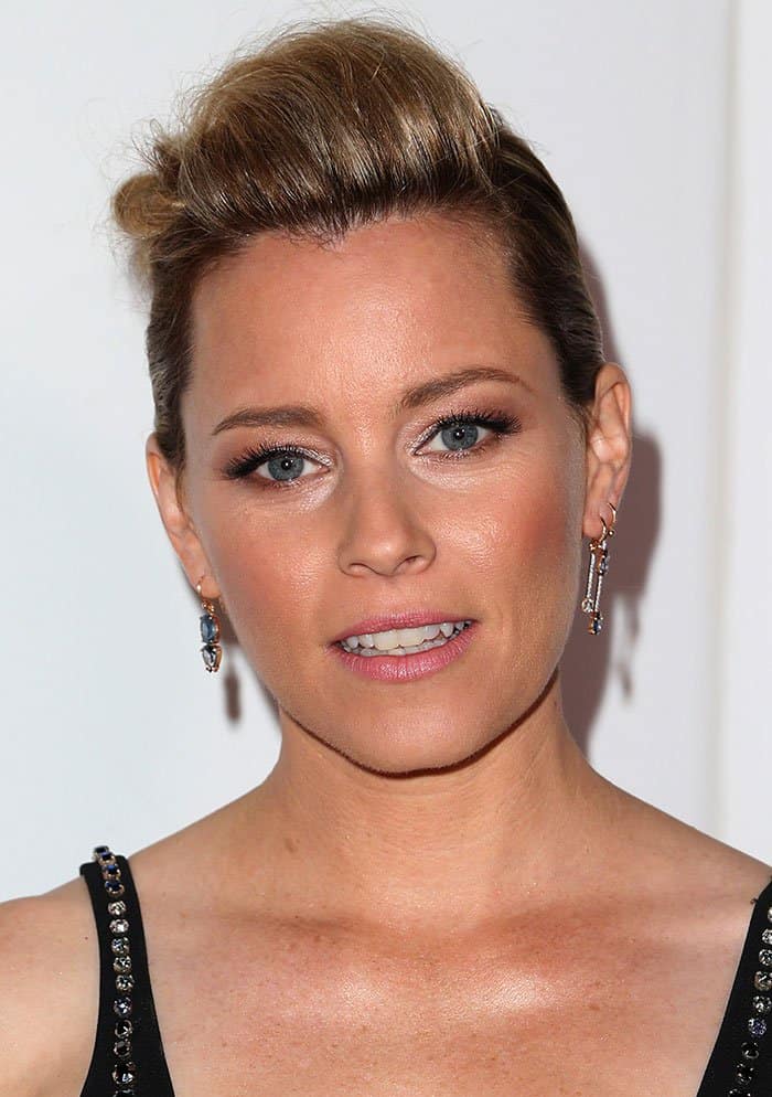 Elizabeth Banks shows off slicked-back hair and statement earrings, paired with shimmering eye makeup