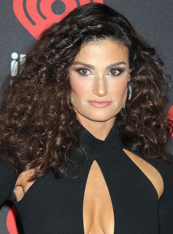 Idina Menzel styled her tresses in voluminous curls and sported smoky eye-makeup and nude pink lipstick