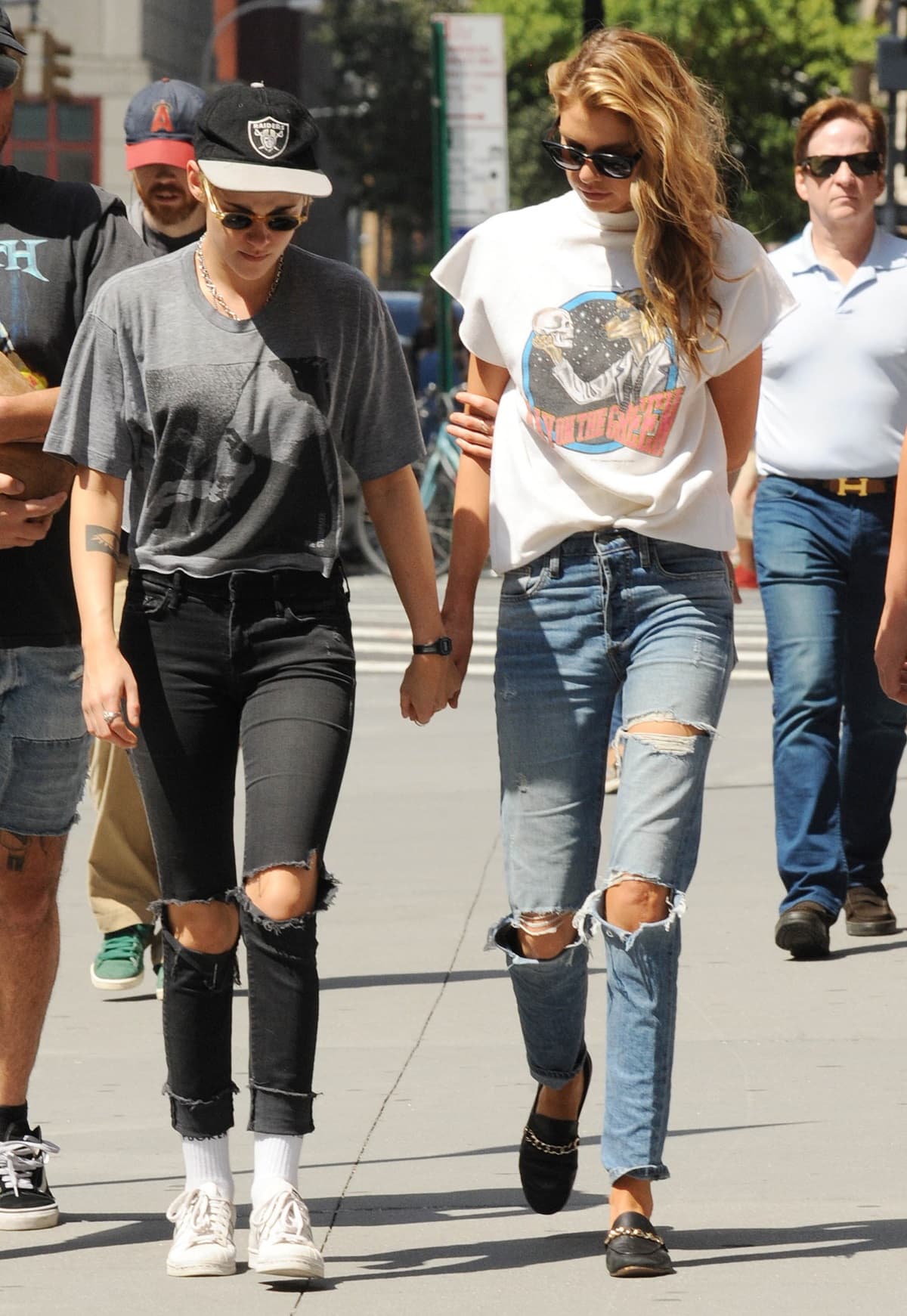 Kristen Stewart and Stella Maxwell keep it effortlessly coordinated in distressed denim and off-duty staples while walking through New York City—Stewart grounding the look in classic white low-top sneakers and Maxwell elevating hers with black leather loafers trimmed in gold chain hardware