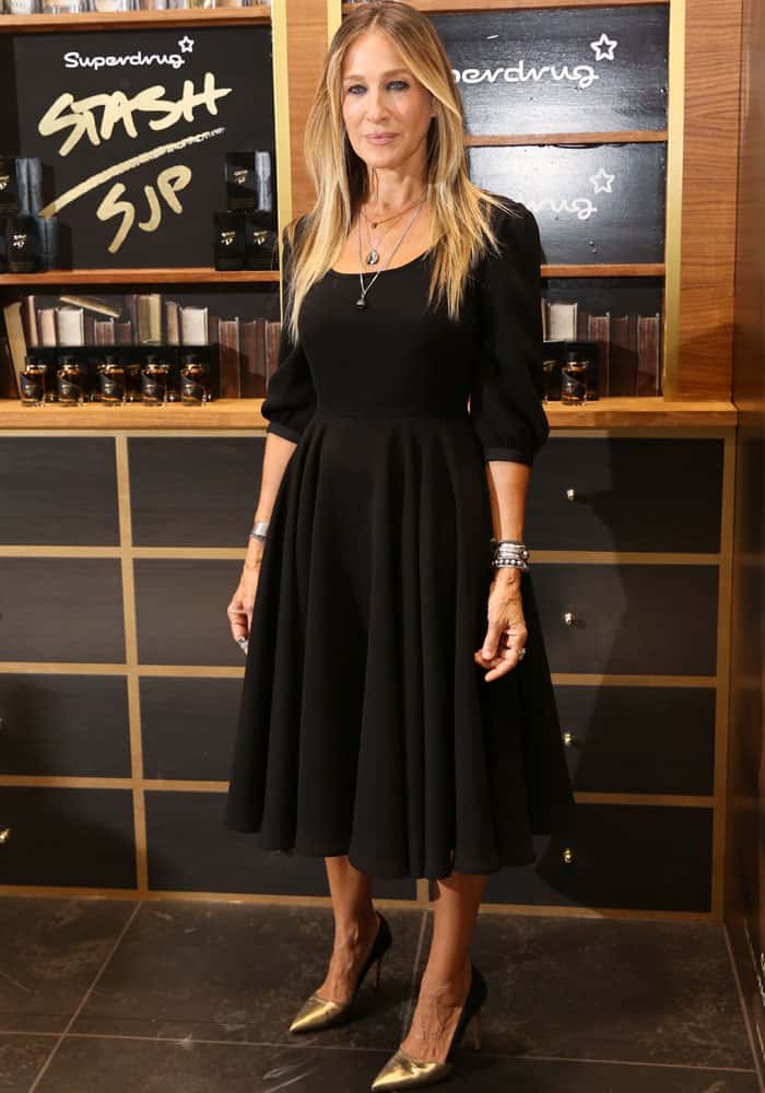 Sarah Jessica Parker launches her fragrance “Stash” at Superdrug in Westfield London on September 14, 2016, wearing a flared black midi dress styled with metallic gold SJP by Sarah Jessica Parker “Rampling” pumps that add a polished flash of shine to the understated look