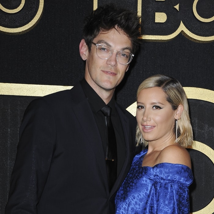 Ashley Tisdale stuns in an off-the-shoulder royal blue dress with a subtle sheen, while her husband, Christopher French, looks sharp in an all-black suit with clear-framed glasses as they attend HBO’s Post 2018 Emmy Awards Reception at the Plaza at the Pacific Design Center in Los Angeles on September 17, 2018