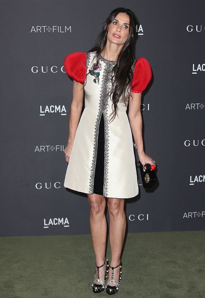 At the 2016 LACMA Art + Film Gala, Demi Moore captivated in a distinctive Gucci silk shantung cocktail dress with dramatic red plissé sleeves, completing her ensemble with the intricate pearl and crystal-embellished Gucci "Ofelia" T-strap pumps