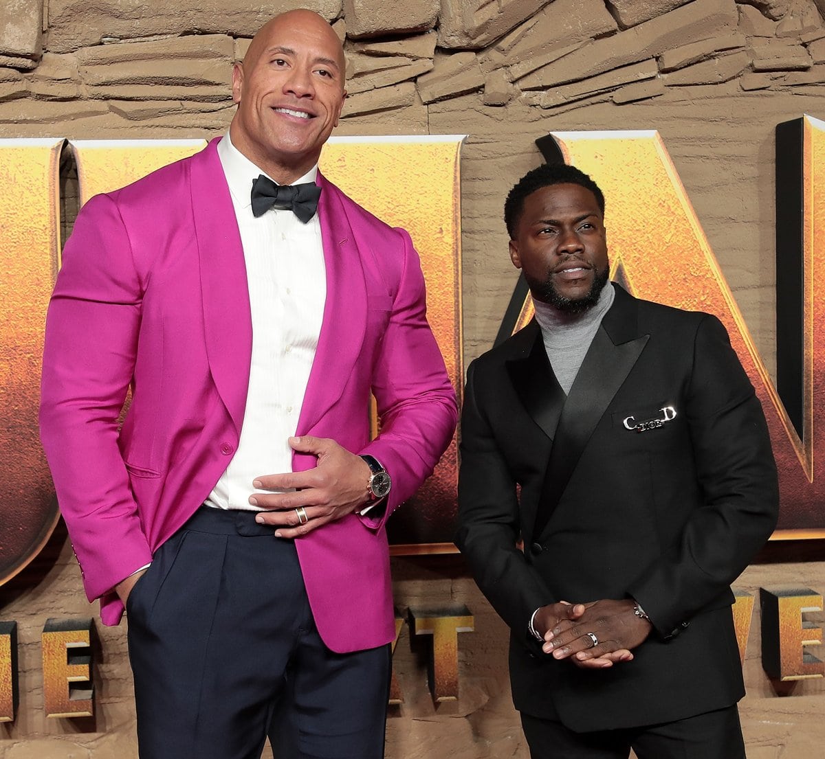 Dwayne "The Rock" Johnson and Kevin Hart steal the spotlight at the Jumanji: The Next Level premiere, with Dwayne making a bold statement in a hot pink blazer and Kevin keeping it sleek in a tailored black suit