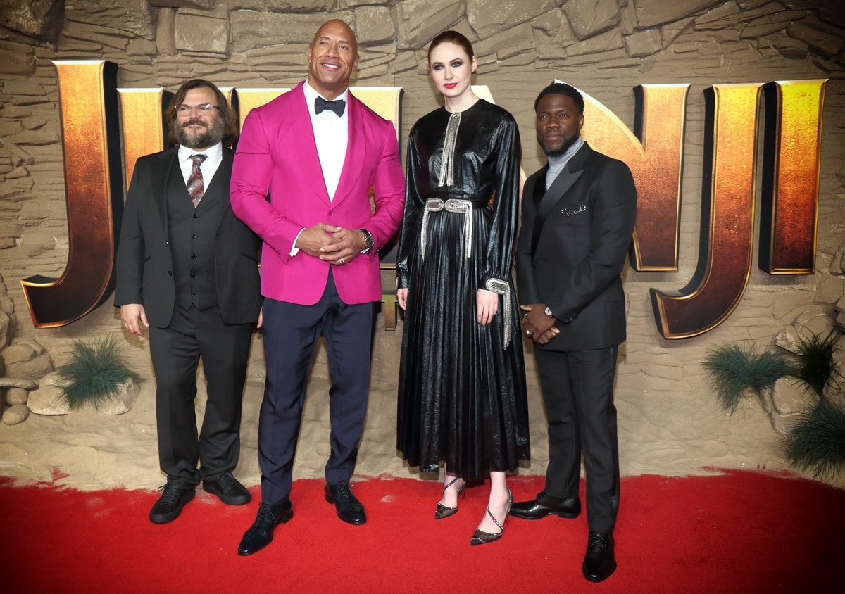 Short actors Jack Black and Kevin Hart suit up stylishly alongside their statuesque Jumanji co-stars, Dwayne Johnson in a bold hot pink blazer and Karen Gillan in a dramatic black leather Christopher Kane Resort 2020 dress paired with strappy pointed heels