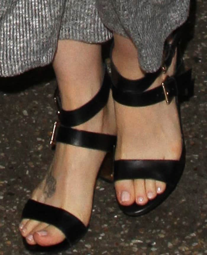 Lily Collins shows off her foot tattoo in black Aldo "Kalika" sandals