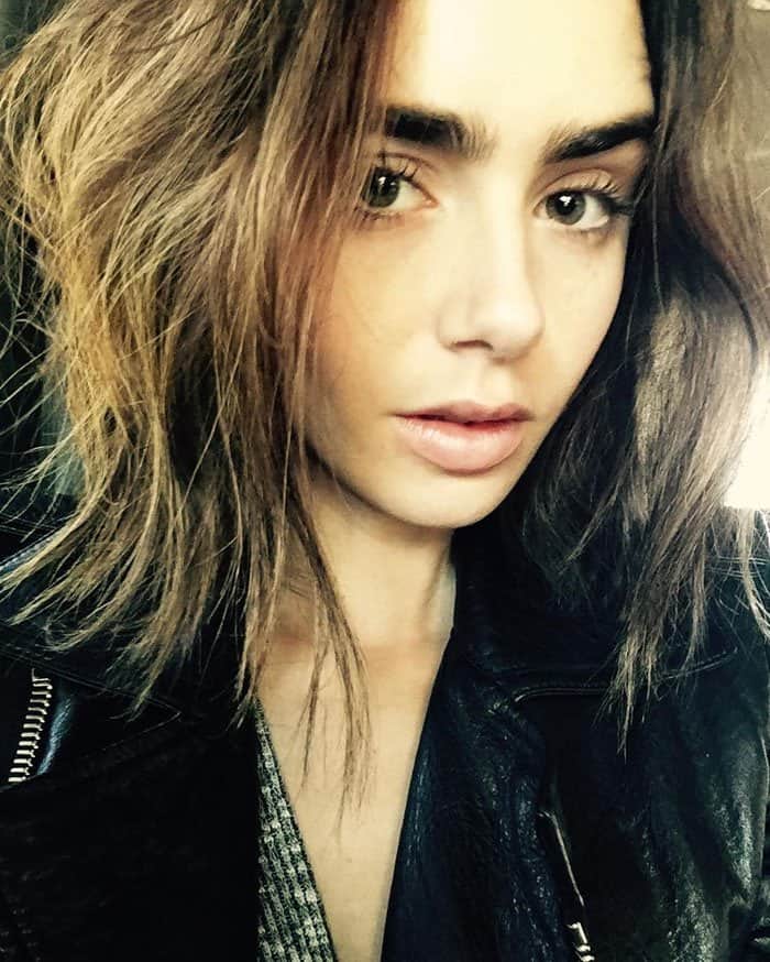 Lily Collins rocks an effortlessly chic look with tousled hair and a black leather jacket, showcasing her natural beauty