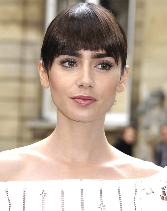Lily Collins' lustrous brunette tresses were expertly gathered into an updo, completing her chic and sophisticated appearance at the Valentino show