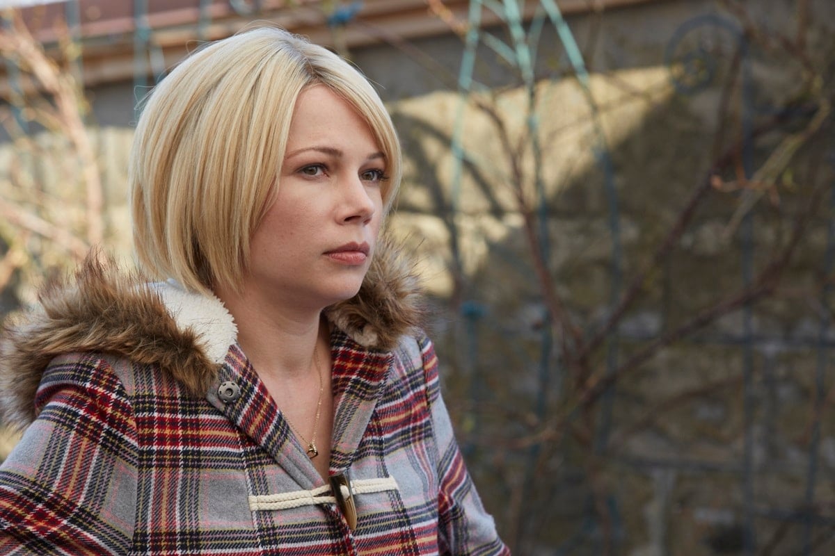 Michelle Williams keeps cozy in a plaid toggle coat with faux fur trim, capturing a quiet moment in Manchester by the Sea