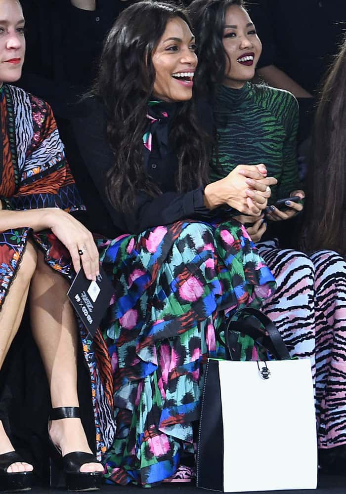Rosario Dawson beams with excitement in the front row, flaunting her vibrant ruffled skirt and zebra-striped boots at the HM x Kenzo runway show