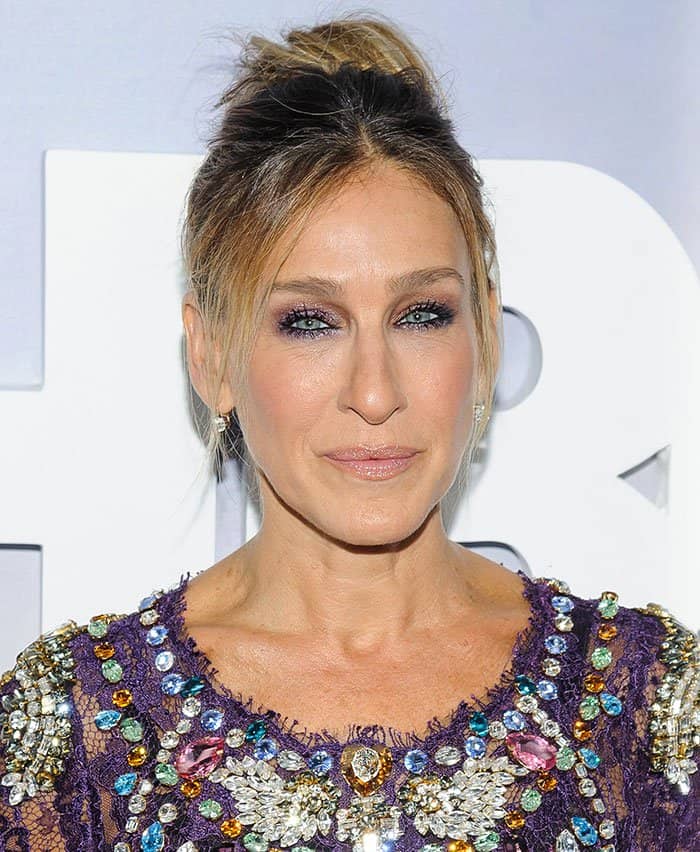 Sarah Jessica Parker wearing her hair in a high updo with shimmering purple eye makeup at the Divorce premiere