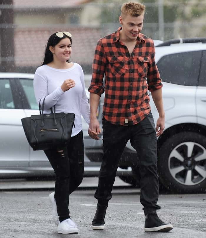 Levi Meaden keeps it casual in a plaid button-up shirt, black jeans, and black high-top sneakers